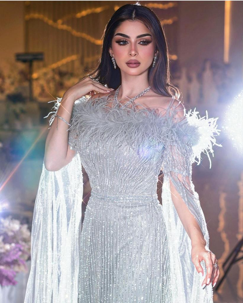 فستان سهرة فضي بالخرز والريش وكاب شفاف